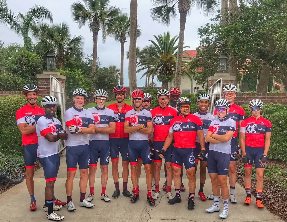 A large group of SP cyclists in team kit posing together before a ride