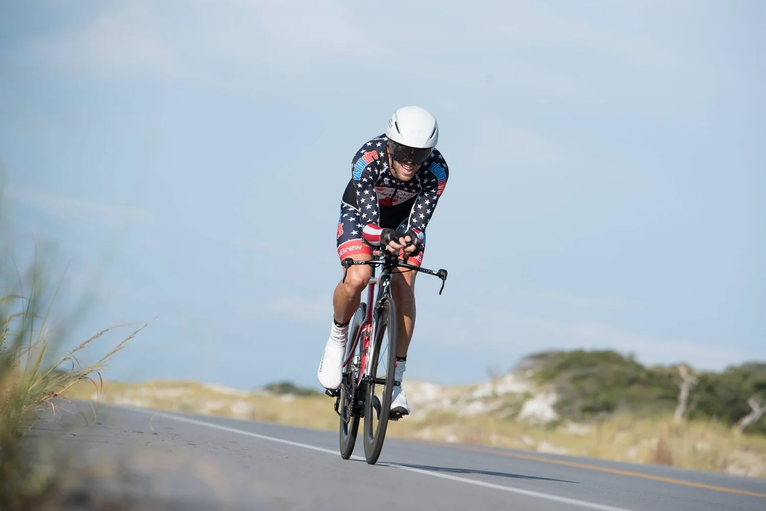 Cyclist in aero position racing solo on an open Florida road